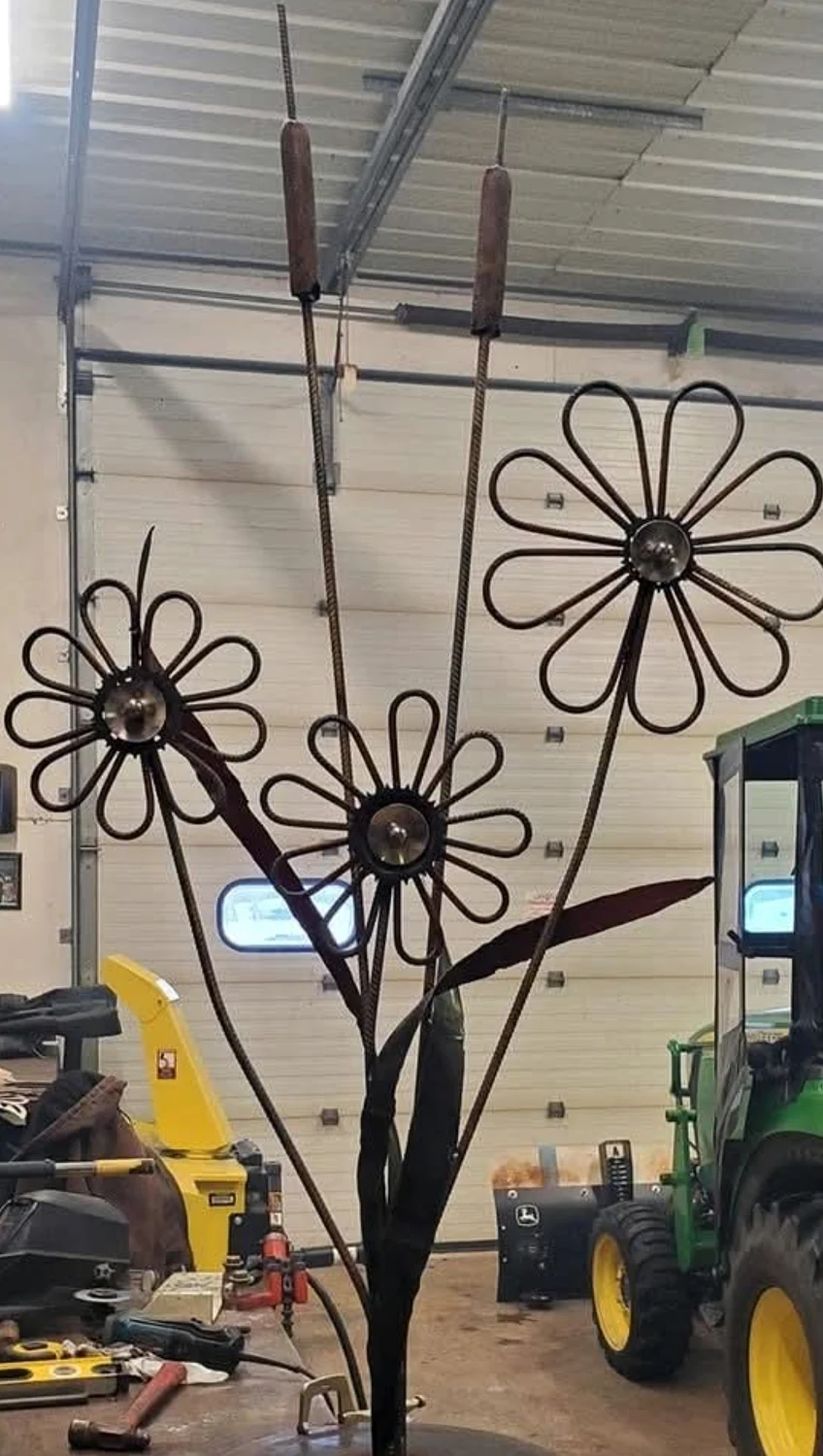 Tall wire flower sculpture in a workshop